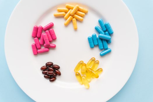 Na zdjęciu znajdują się suplementy diety w kapsułkach z zawartością witamin i kwasów omega-3