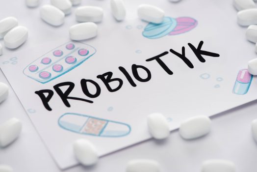 Probiotyki - napis wśród kapsułek probiotycznych