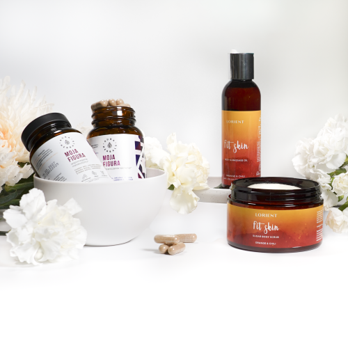 Zestaw aura herbals - zestaw 3-7, zawierający butelki z suplementami, kapsułki, butelkę z pompką i słoik z peelingiem do ciała, jest ułożony na białej powierzchni z białymi kwiatami.