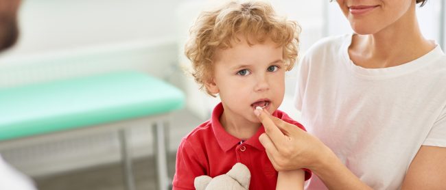 Mały chłopiec przyjmuje colostrum w kapsułkach