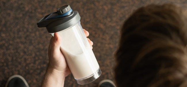 Bodybiulder pije odżywkę białkową z dodatkiem kolagenu