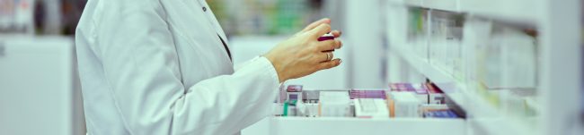 Magister farmacji wyjmuje kolagen z aptecznej półki