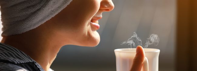 Kobieta pije kolagen w ciepłej wodzie (30 stopni Celsjusza)