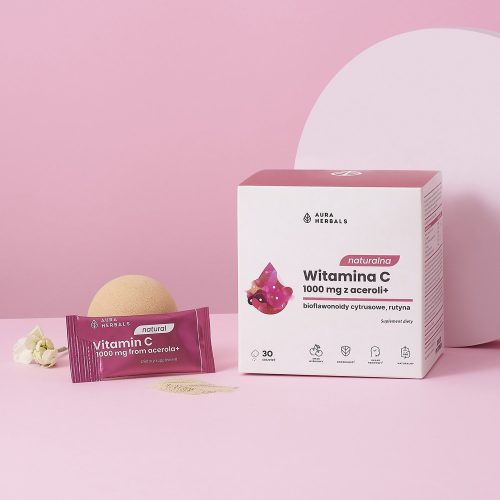 Na różowym tle widnieje pudełko i saszetka produktu „Naturalna witamina C 1000 mg z aceroli – saszetki 30 szt. – 1500x1500-1” wraz z małym kwiatkiem, gąbką i proszkiem witaminowym.