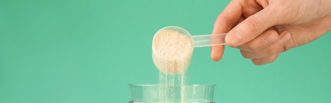 Kobieta dodaje kolagen w proszku do szklanki z wodą