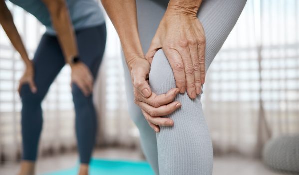 Kobieta po 50 roku życia chwyta się za bolące kolano