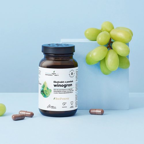 Butelka preparatu „Ekstrakt z pestek winogron – 550 mg – 95 OPC – kapsułki – 60 szt.” jest przedstawiona obok zielonych winogron, sypkich kapsułek i jasnoniebieskiego bloku, a całość umieszczono na jasnoniebieskim tle.