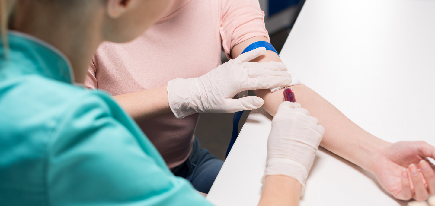 Pielęgniarka pobiera pacjentowi krew na test poziomu żelaza we krwi